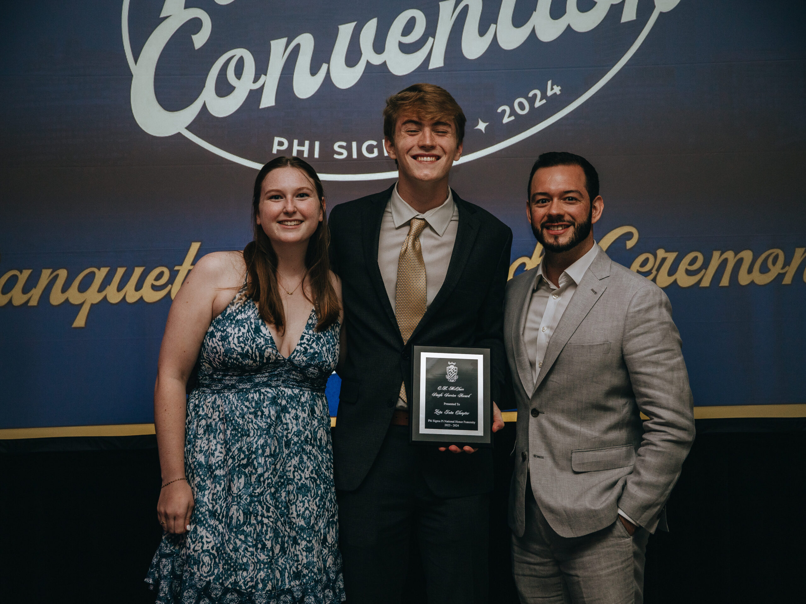 Three Members standing together with an award