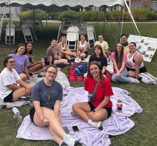 Members sitting together on a picnic blanket