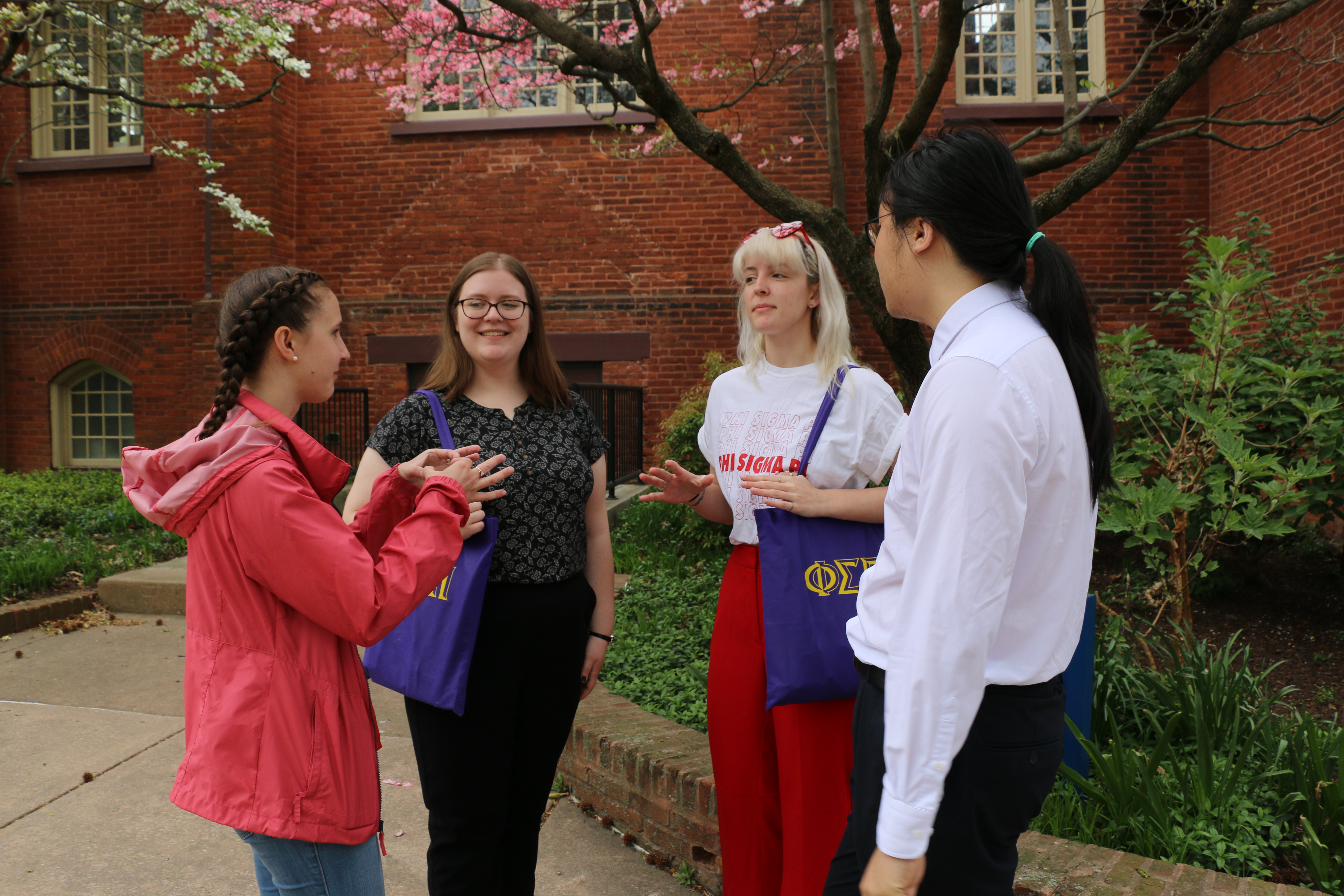 Four Members standing and talking to each other.