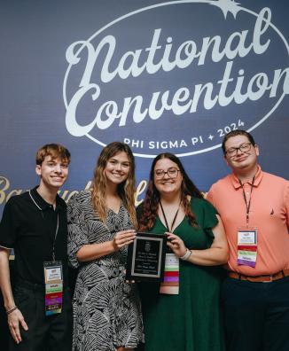4 Members stand holding award at National Convention